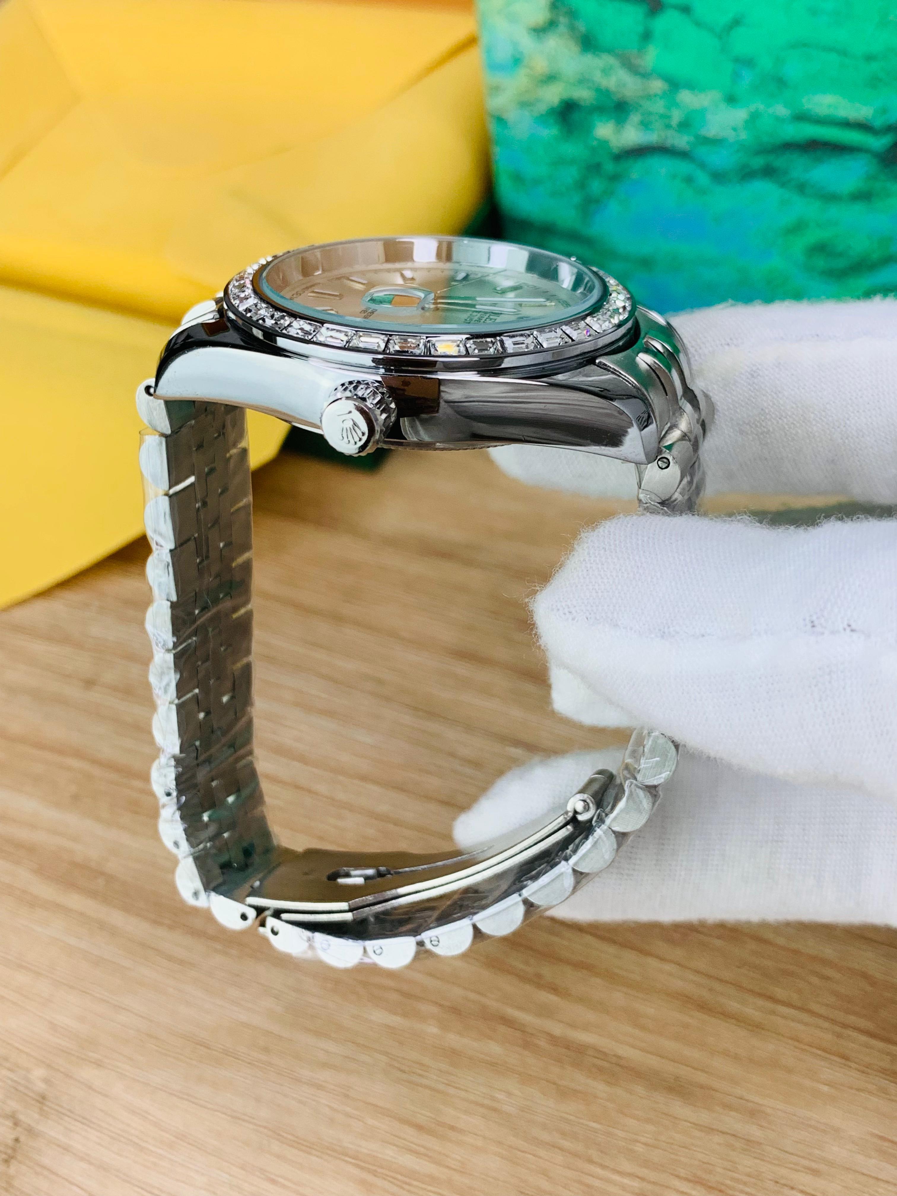 Side view of two-tone stainless steel jubilee chain watch with black stone dial