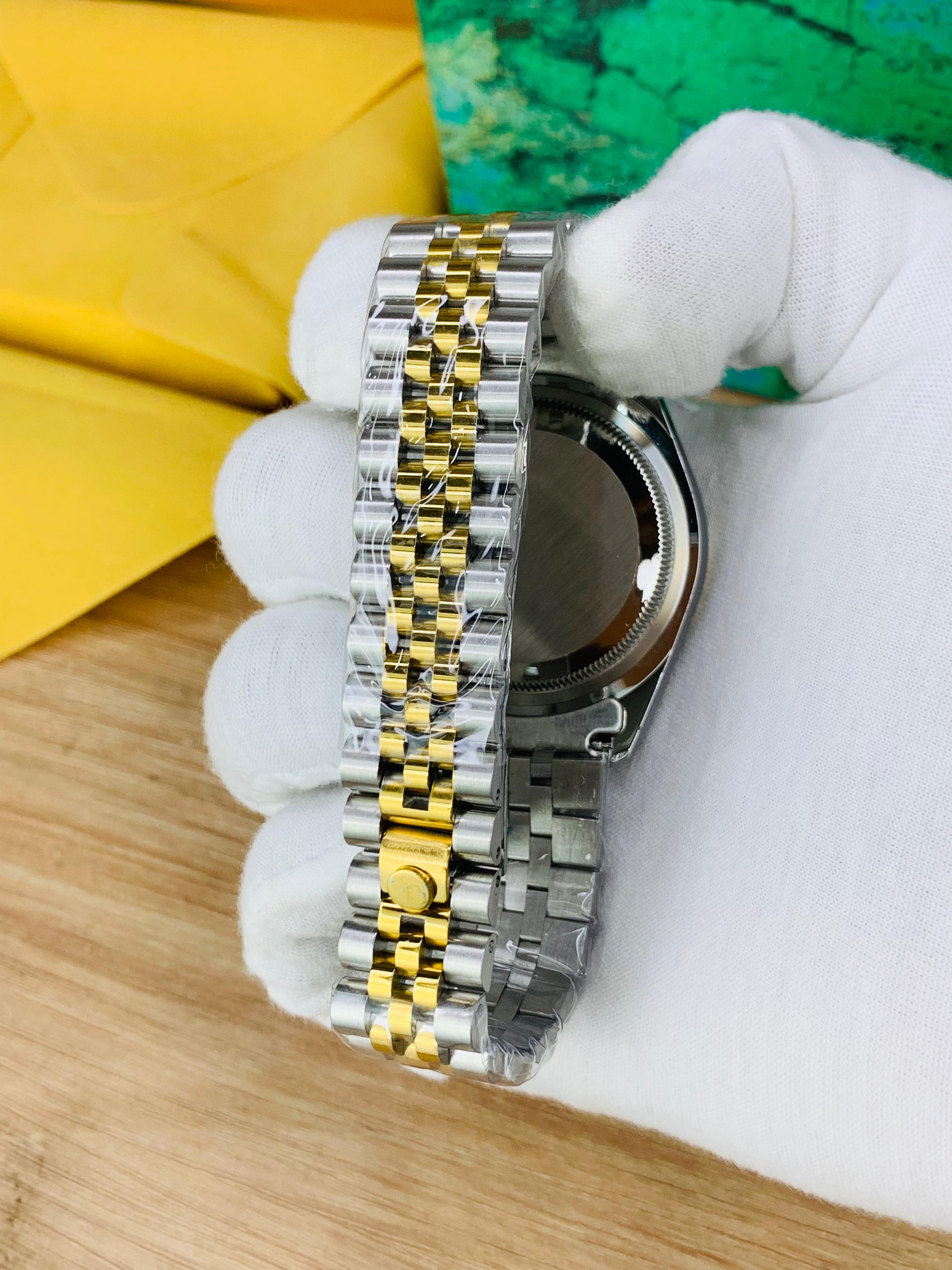 Two-tone jubilee chain close-up of luxury men’s watch with blue stone dial